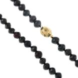 A garnet single-strand necklace, with engraved push-piece clasp.