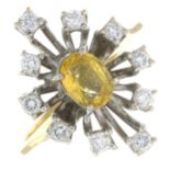 An 18ct gold ring, set with a yellow sapphire, within a brilliant-cut diamond spray surround.