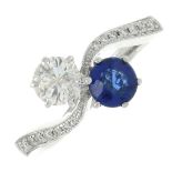 A sapphire and brilliant-cut diamond two-stone crossover ring.Estimated total diamond weight