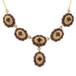 A garnet cluster pendant, with integral trace-link chain.Stamped 750.Length 43cms.