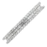 An 18ct gold brilliant and baguette-cut diamond three-row eternity ring.Estimated total diamond