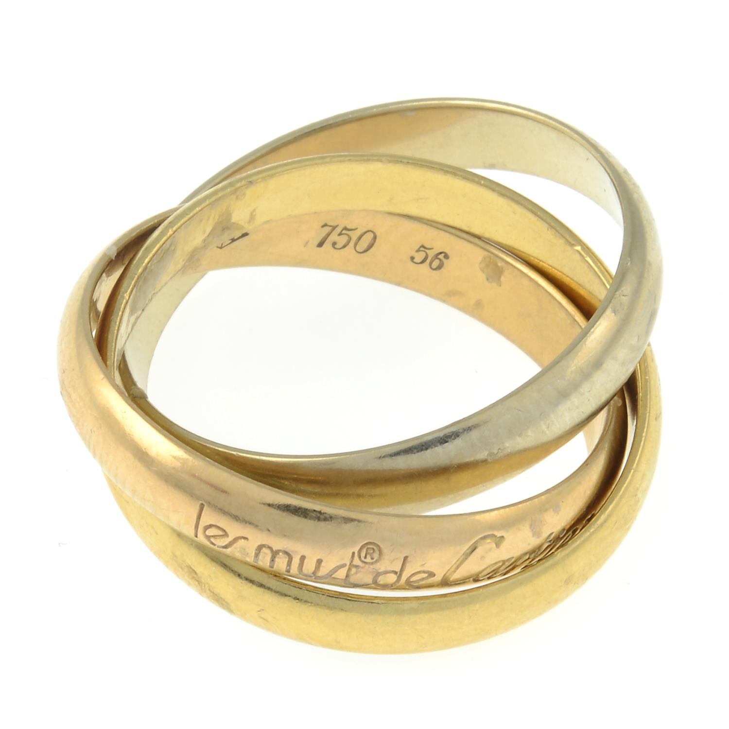 A 'les must de Cartier, Trinity' ring, by Cartier.Signed Cartier, A6359L.Stamped 750.Ring size O. - Image 2 of 2