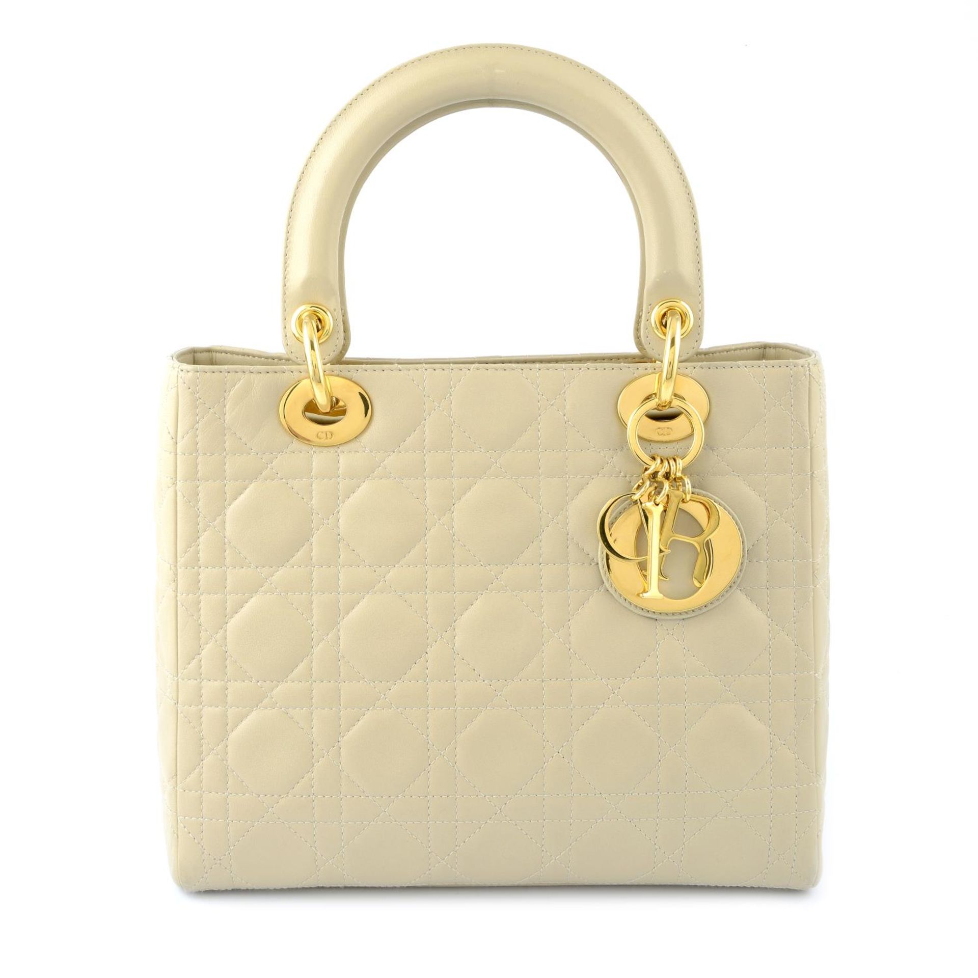 CHRISTIAN DIOR - a beige cannage leather Lady Dior handbag.