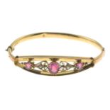 An Edwardian 9ct gold red garnet-topped-doublet and split pearl openwork bangle.Hallmarks for