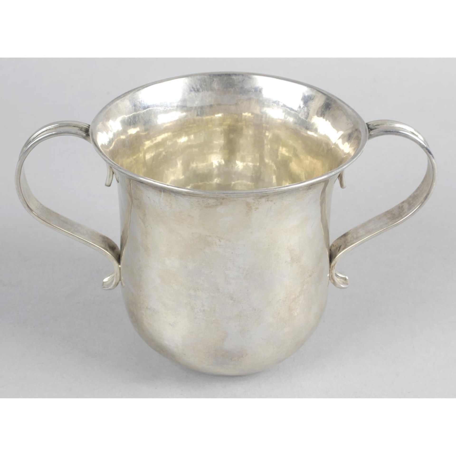 A George II silver porringer, the plain body with flared rim and twin scroll handles.