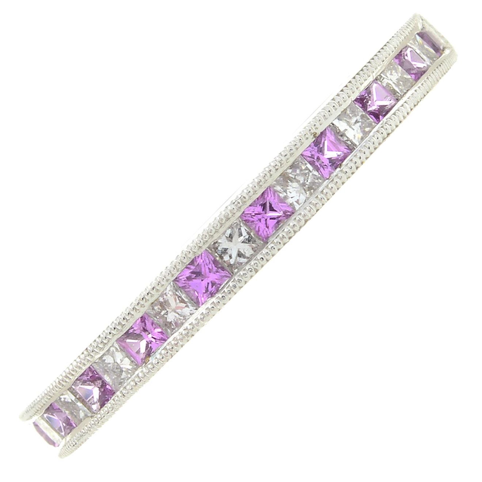 An 18ct gold pink sapphire and diamond half eternity ring.Total pink sapphire weight 0.24ct,