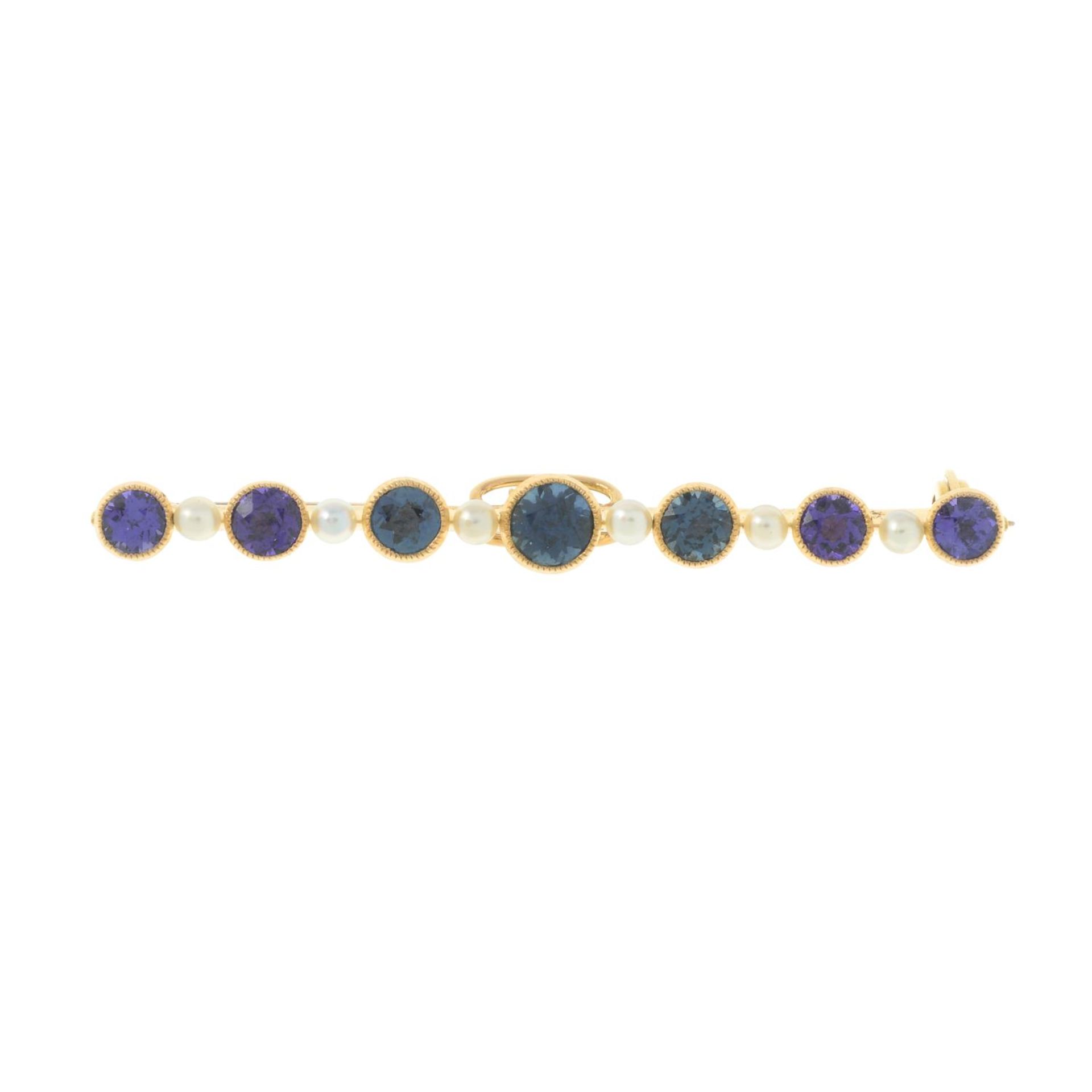 An early 20th century 15ct gold purple and green sapphire bar brooch,