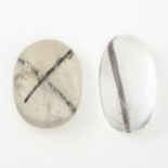 Two tourmalinated quartz cabochons, weighing 28.02ct and 31.32ct.