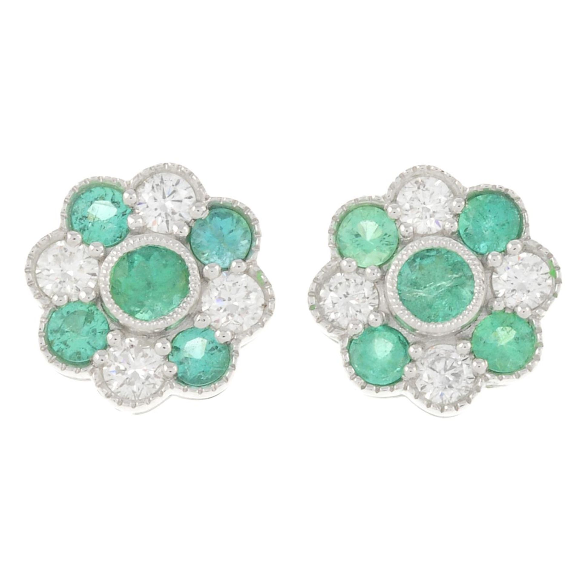 A pair of 18ct gold emerald and brilliant-cut diamond floral cluster earrings.Total emerald weight