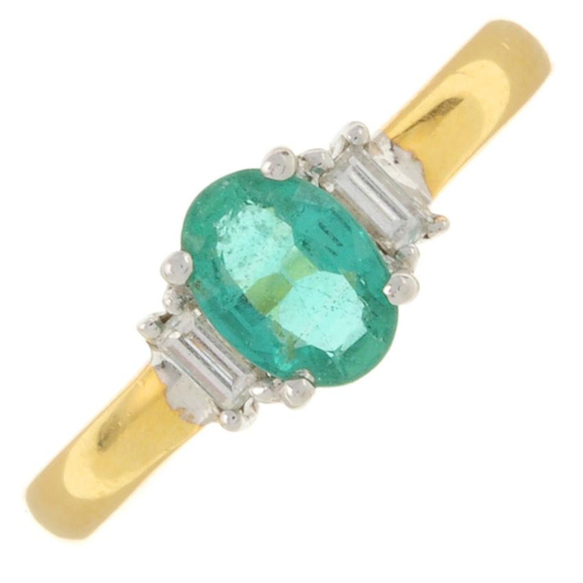 An 18ct gold emerald and baguette-cut diamond three-stone ring.Emerald calculated weight 0.65ct,