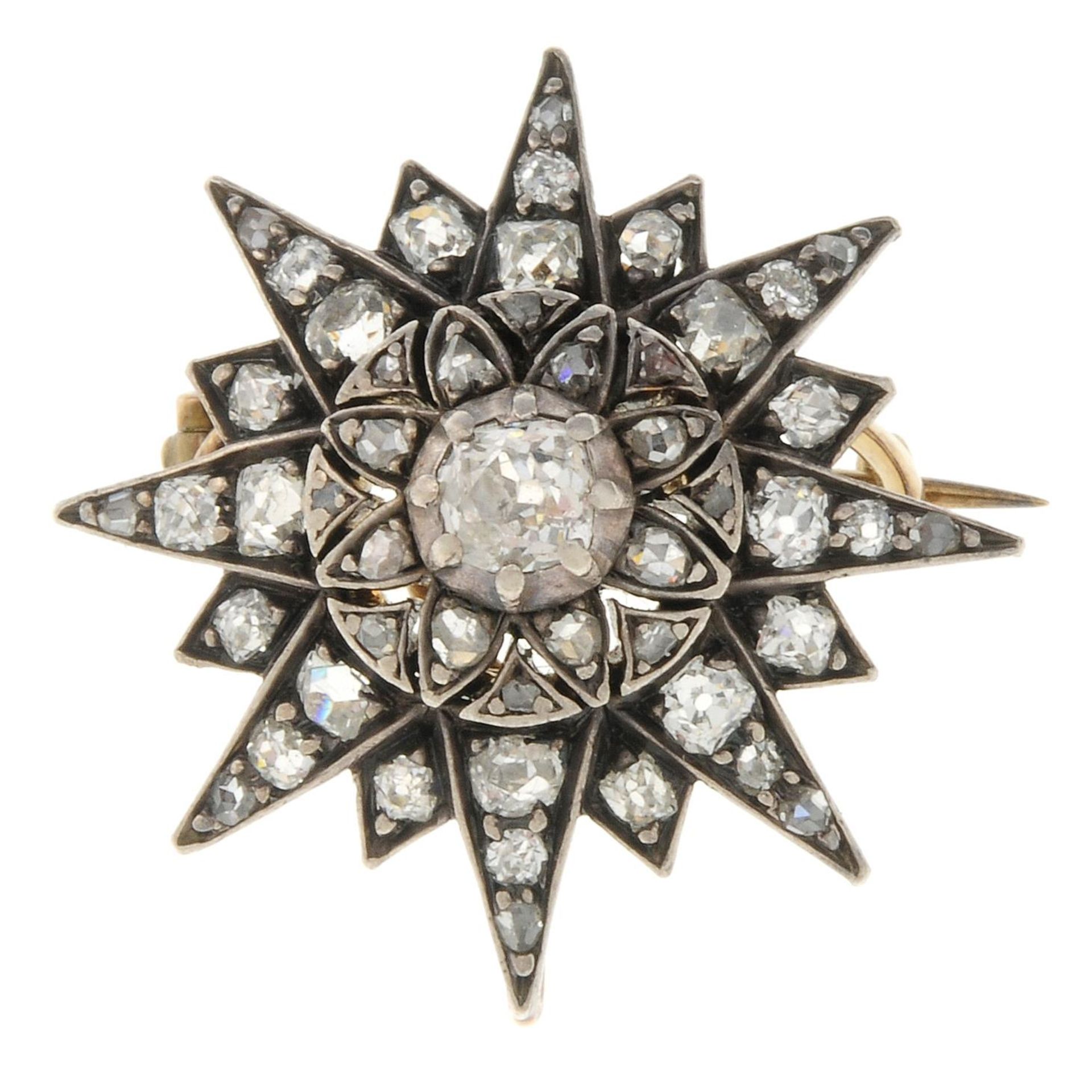 An early 20th century gold and silver old-cut diamond star brooch.May be worn as a pendant.