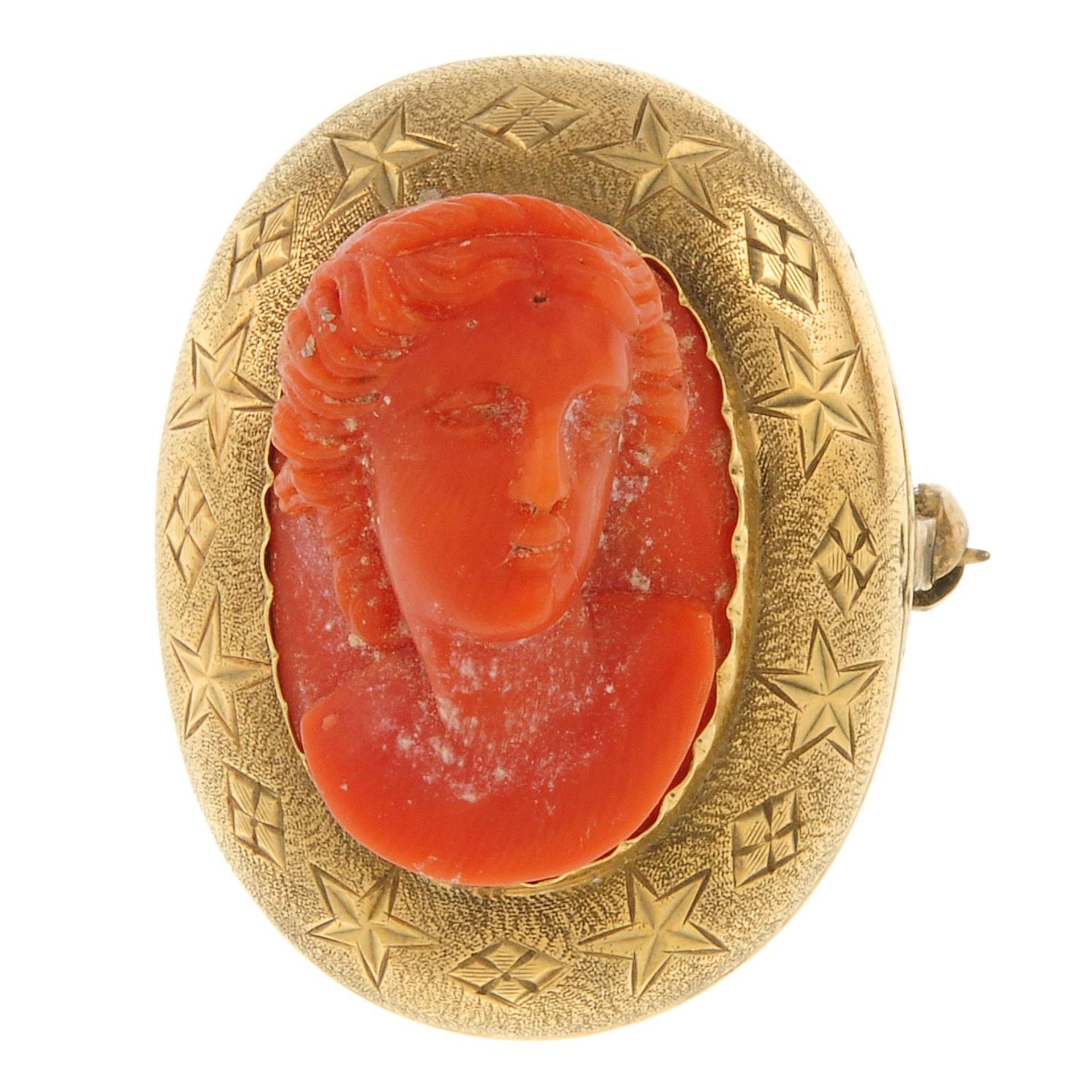 A late 19th century gold coral cameo brooch, coral carved to depict a bust.Length 2.9cms.