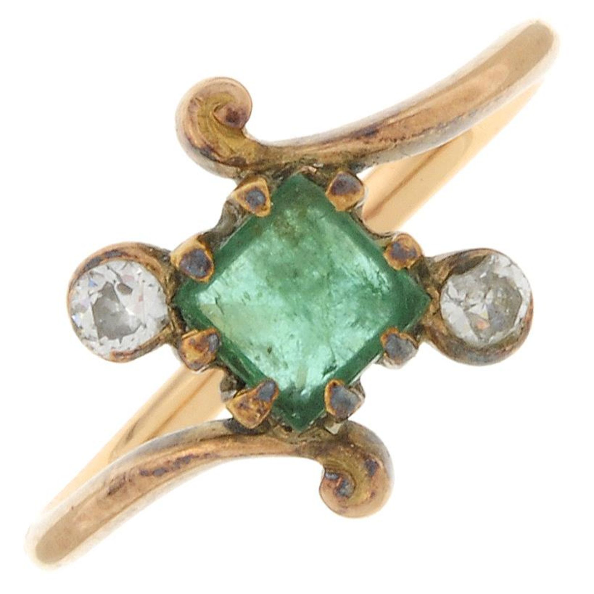 An early 20th century gold emerald and diamond crossover ring.