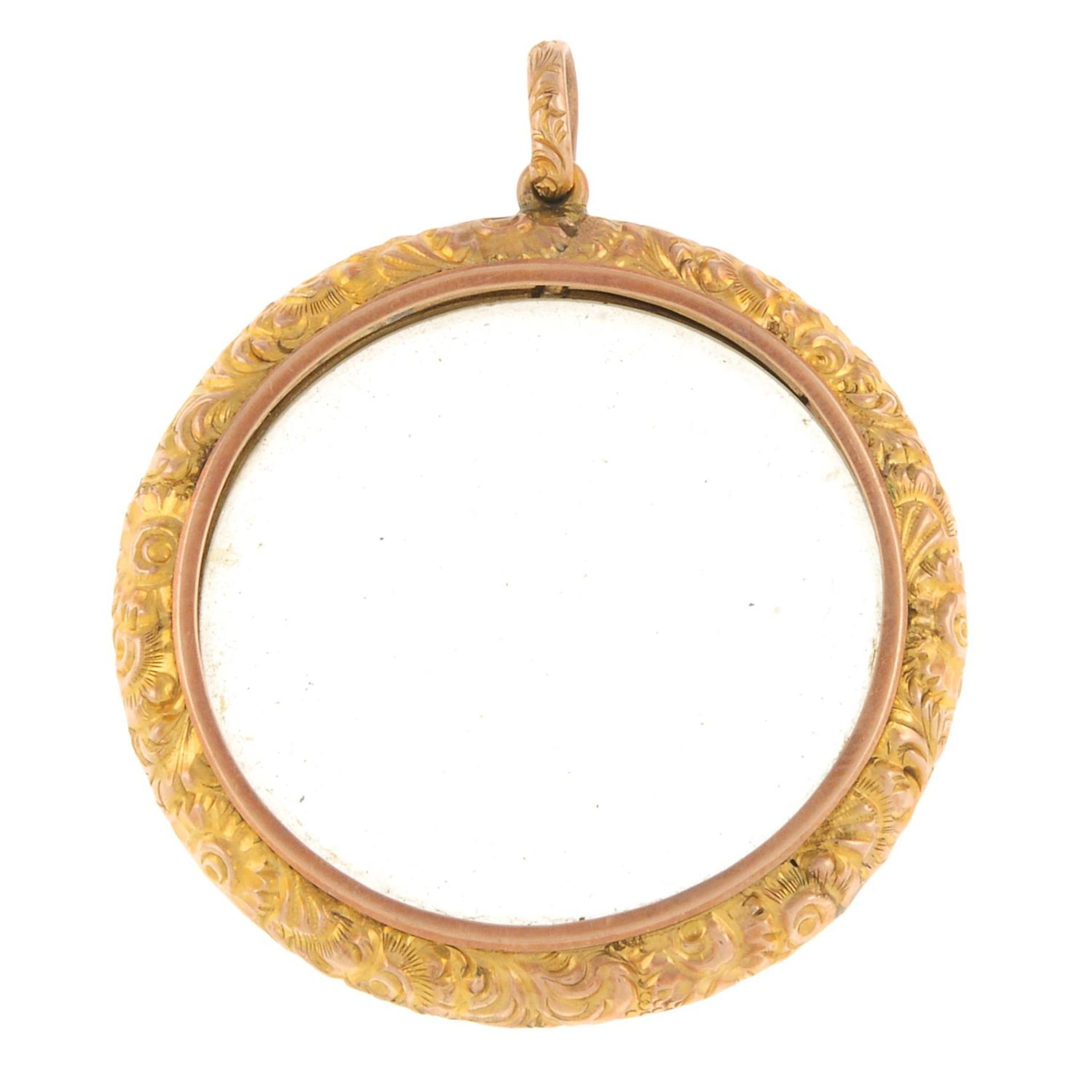 A late 19th century gold locket, with scrolling foliate surround and surmount.