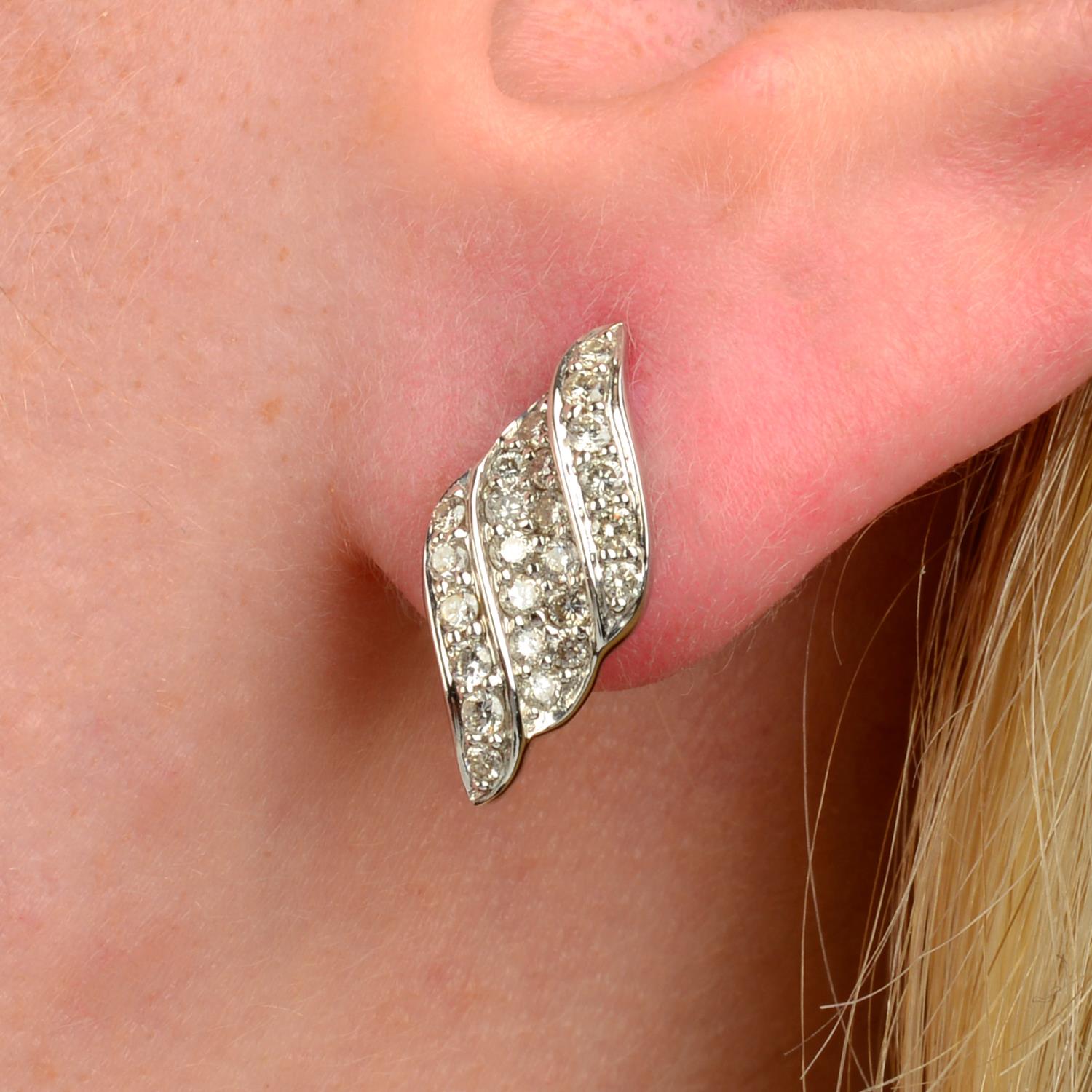 A pair of 18ct gold brilliant-cut diamond scroll motif earrings.Total diamond weight 0.55ct,