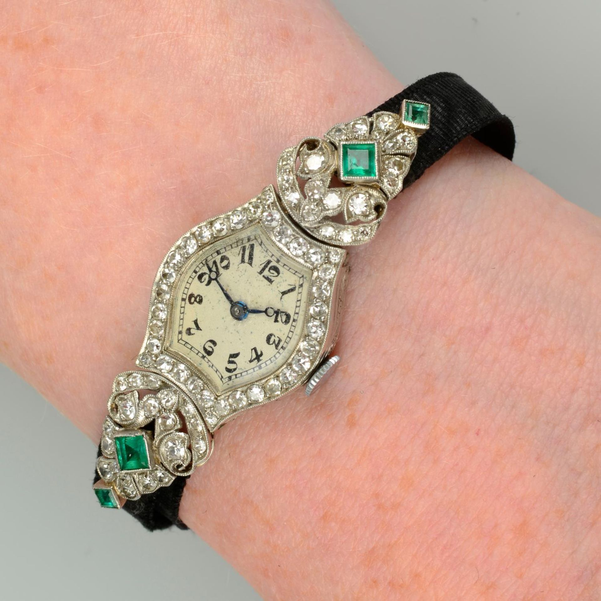 An Art Deco platinum emerald and diamond cocktail watch, with fabric strap.