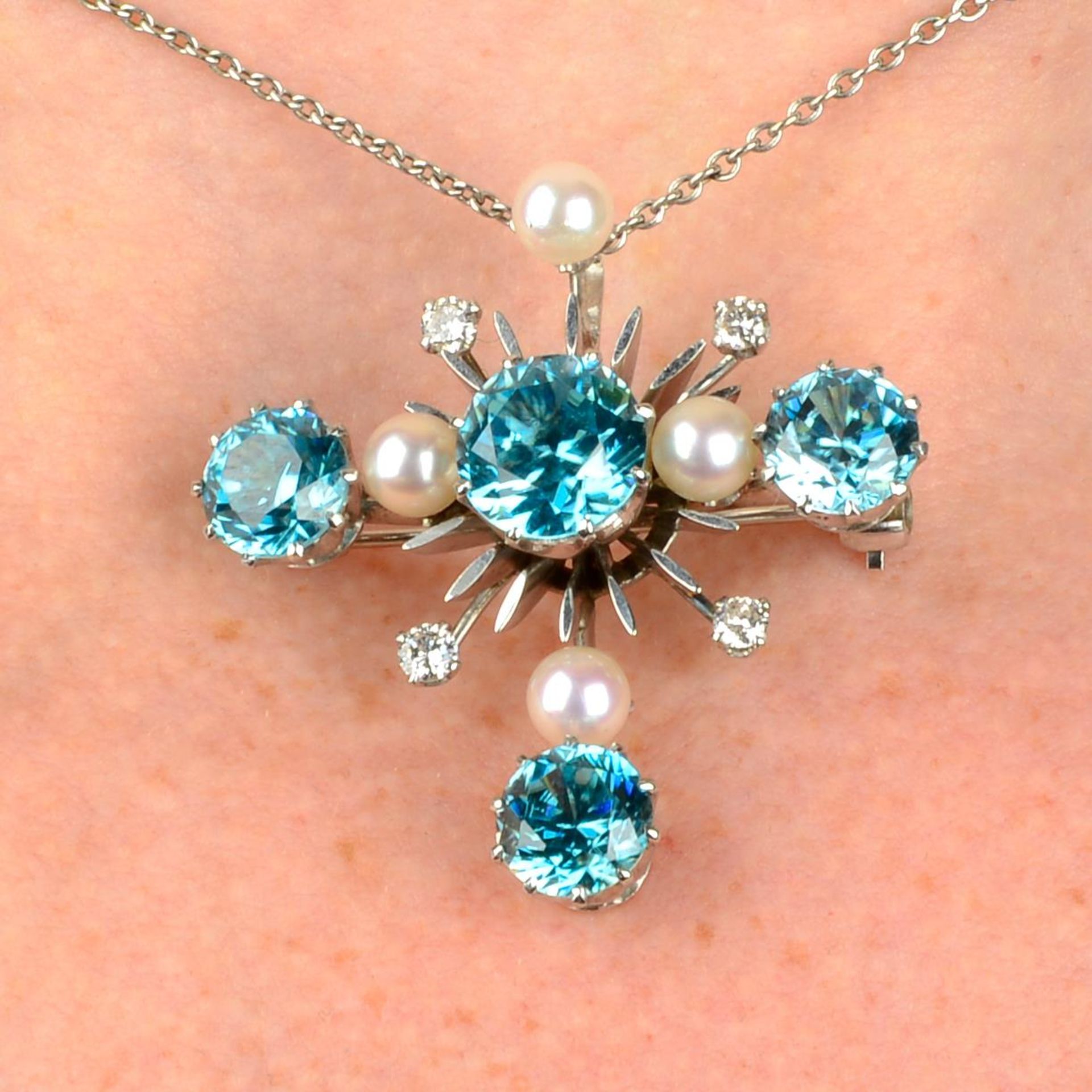 A blue zircon, cultured pearl and diamond pendant, with chain.