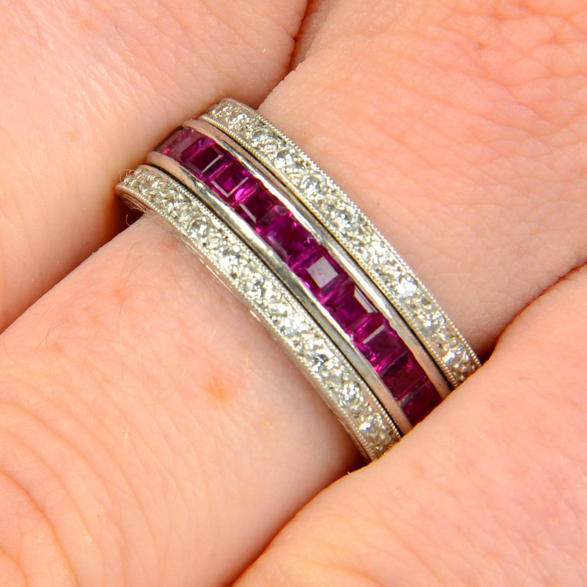 An 18ct gold sapphire and ruby full eternity ring, with pavé-set diamond hinged sides.