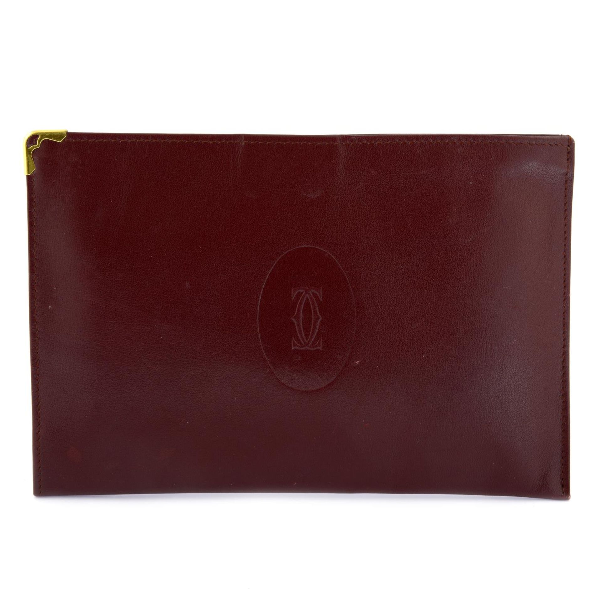 CARTIER - a Bordeaux leather purse.