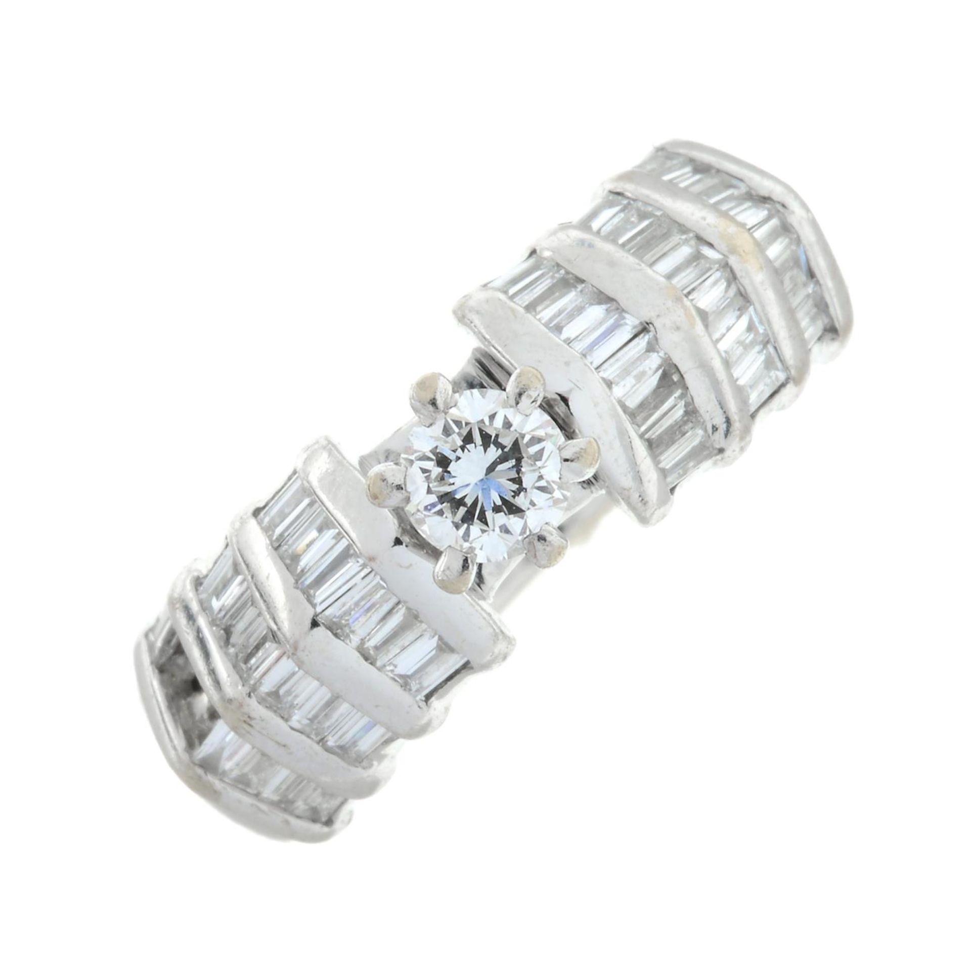 A brilliant and baguette-cut diamond dress ring.Diamond deficient.