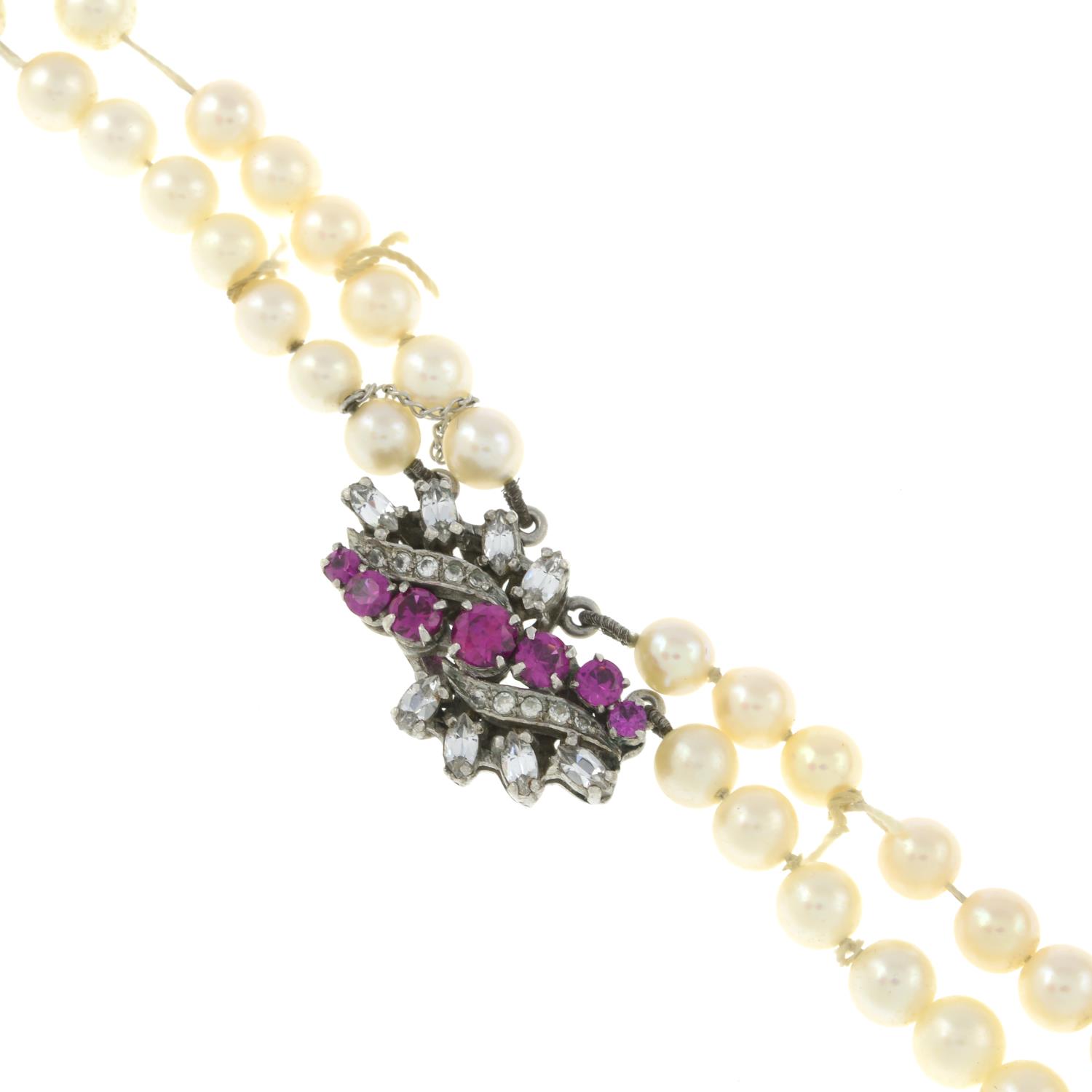 A four-strand cultured pearl necklace with a pink paste clasp.