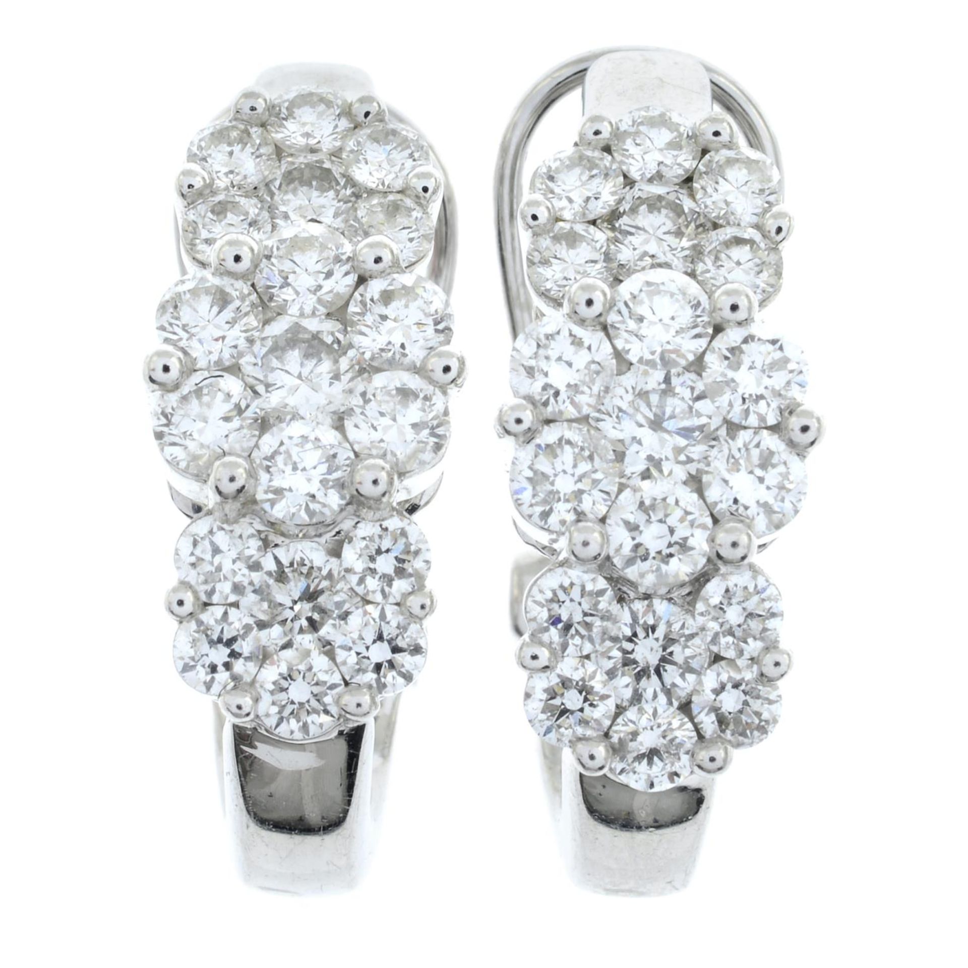 A pair of brilliant-cut diamond triple cluster earrings.