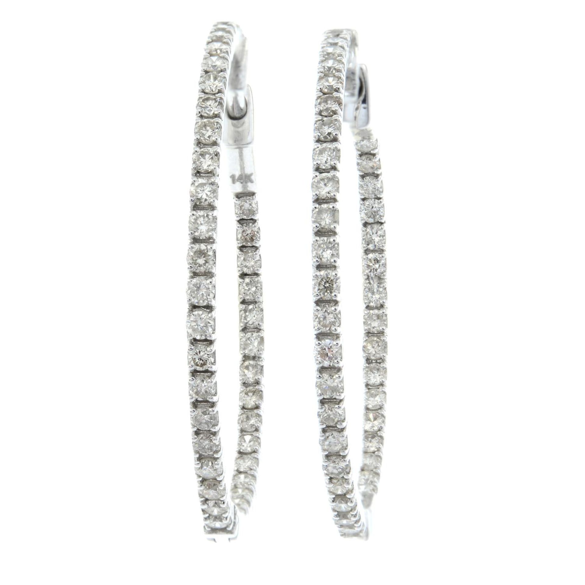 A pair of diamond hoop earrings.Estimated total diamond weight 0.45ct.