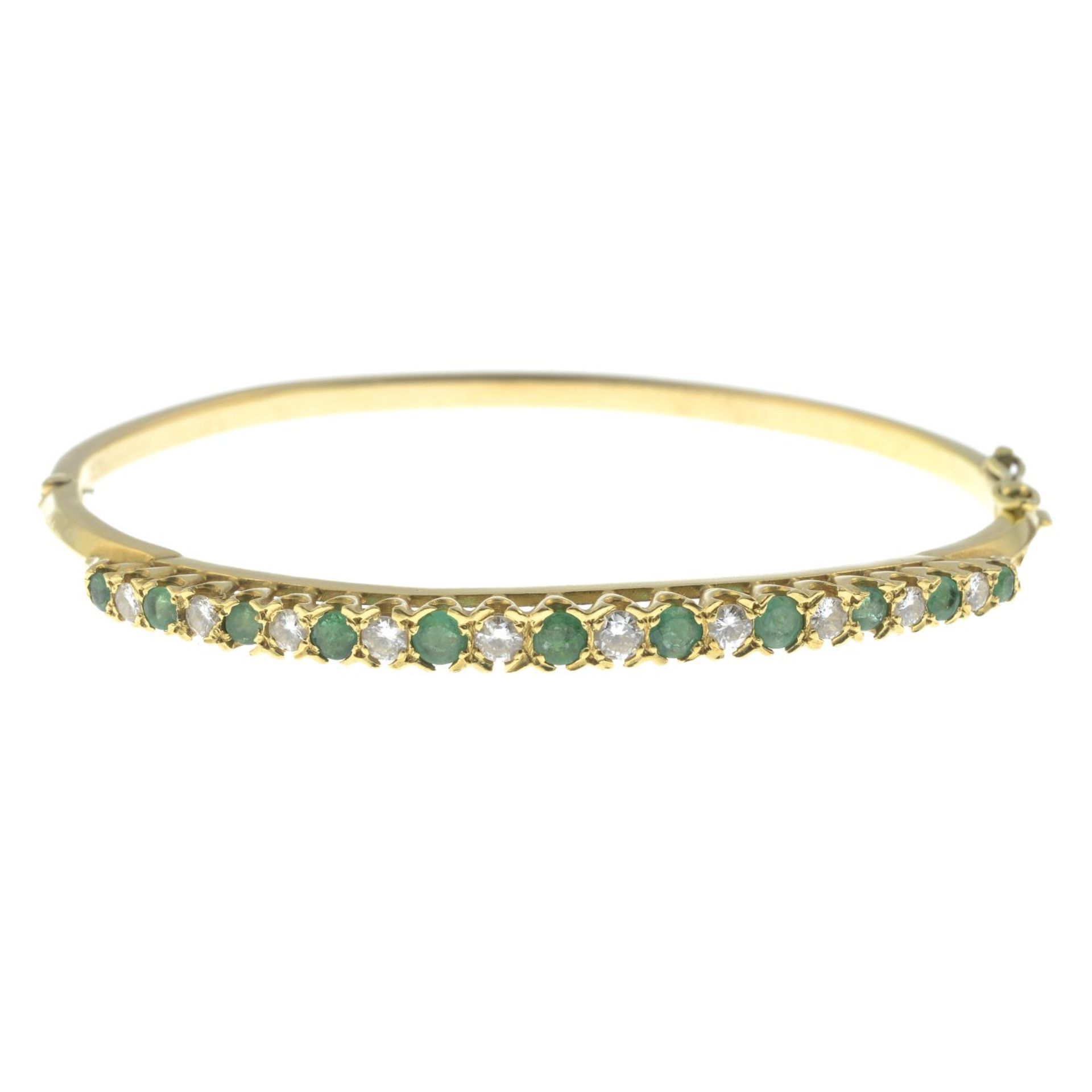 An emerald and diamond bangle, hinged to the plain reverse.