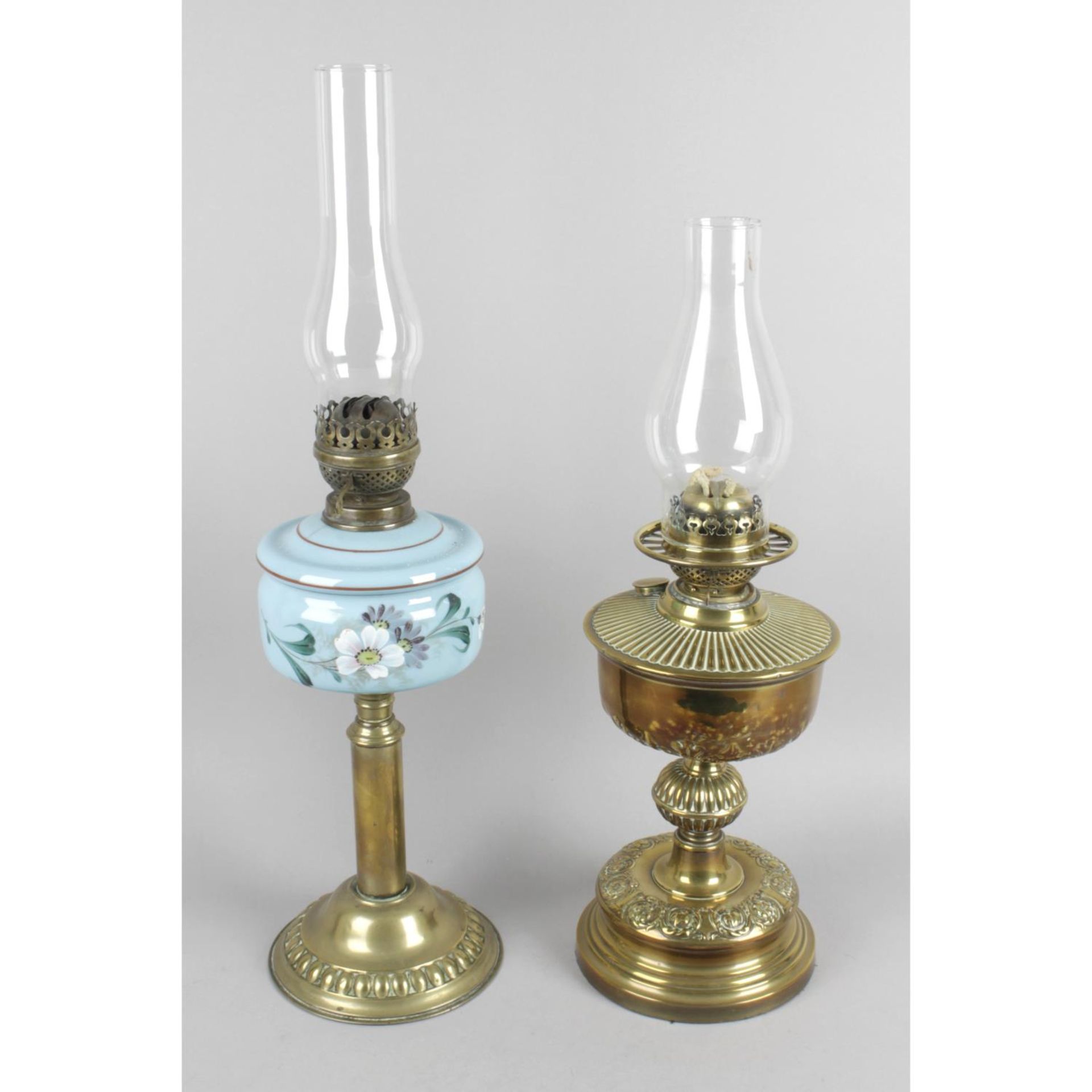 A Victorian brass table lamp with floral decorated blue glass reservoir and Duplex burner.
