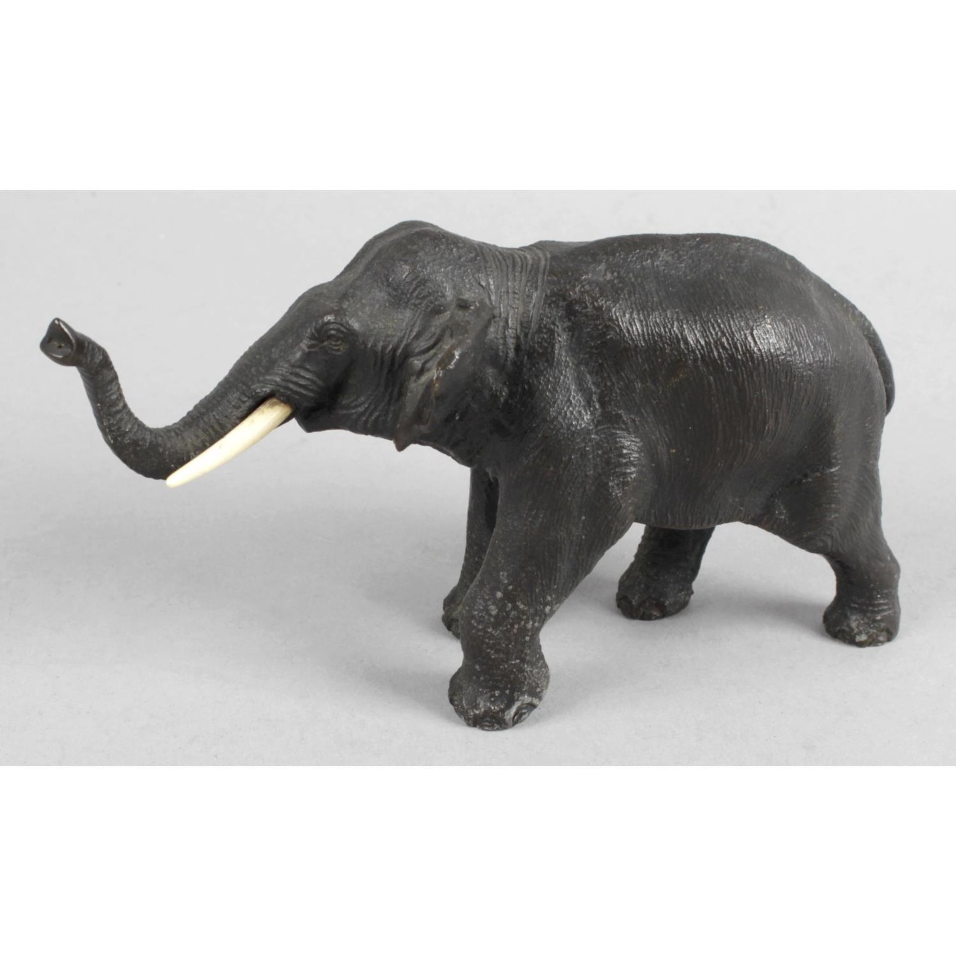 A Japanese Meiji period bronzed elephant, upstanding with head facing forward and trunk raised.