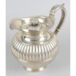 A turn of the century silver teapot of circular form,