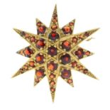 A 9ct gold garnet star brooch.May be worn as a pendant.Hallmarks for 9ct gold.