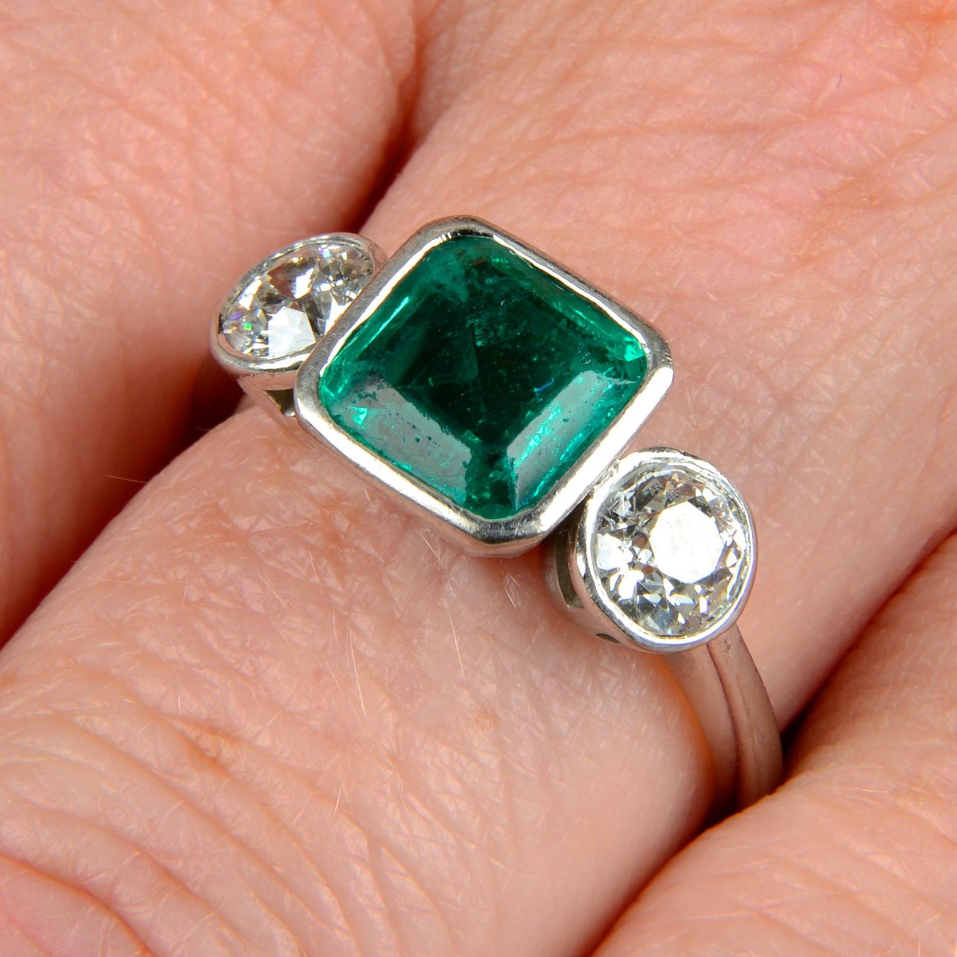 An 18ct gold emerald and old-cut diamond three-stone ring.Emerald calculated weight 1.04cts,