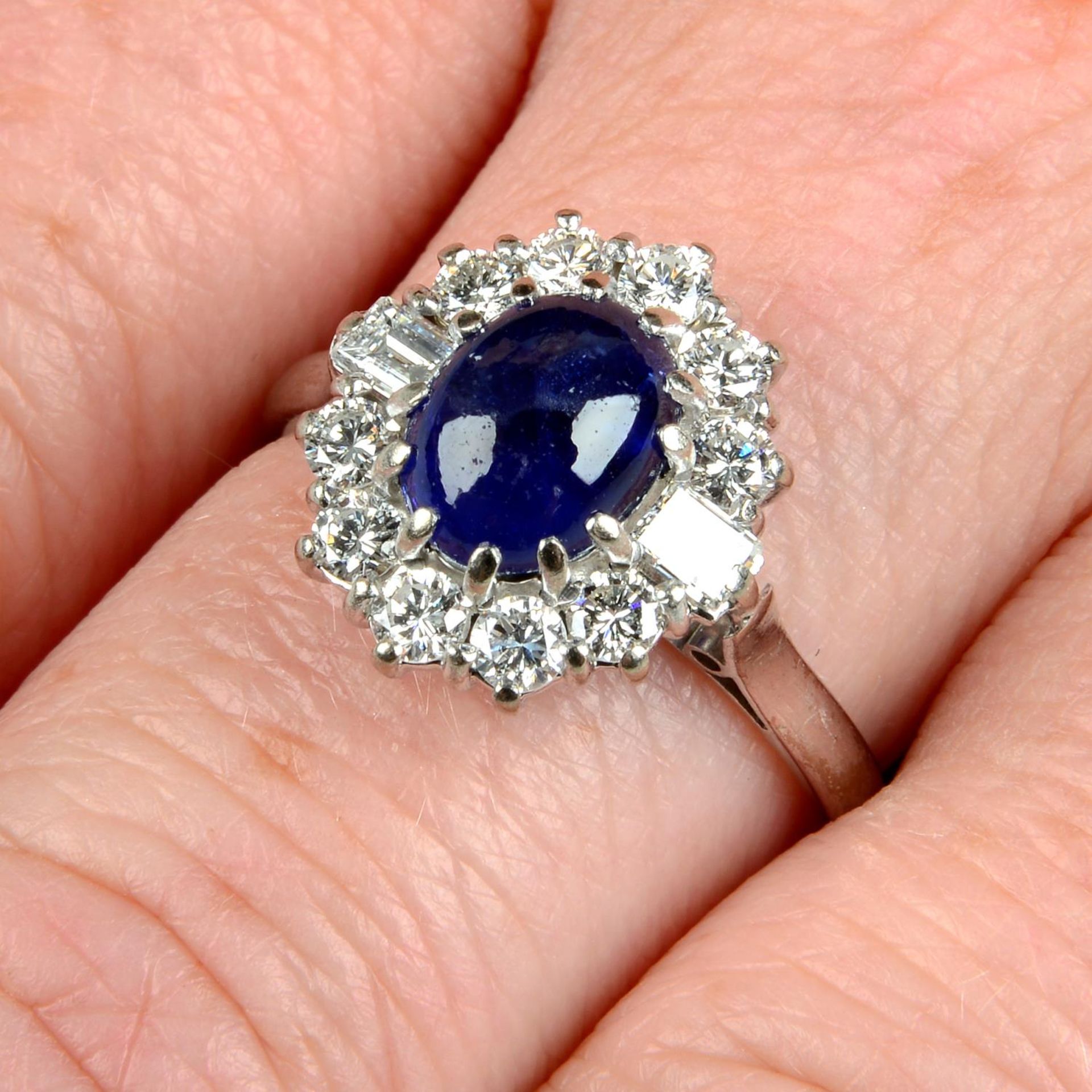 An 18ct gold sapphire cabochon and vari-cut diamond ring.Sapphire calculated weight 1.89cts,