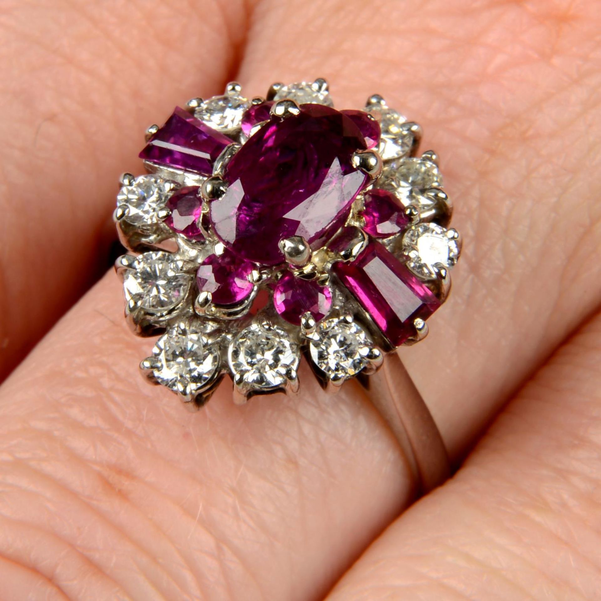 A vari-cut ruby and brilliant-cut diamond dress ring.Principal ruby calculated weight 1.23cts,