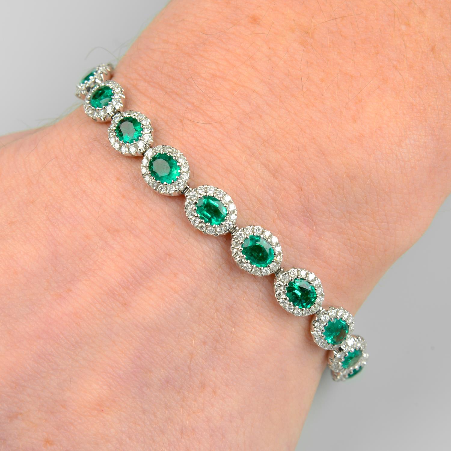 An 18ct gold emerald and diamond cluster link bracelet.Total emerald weight 6.23cts.Total diamond