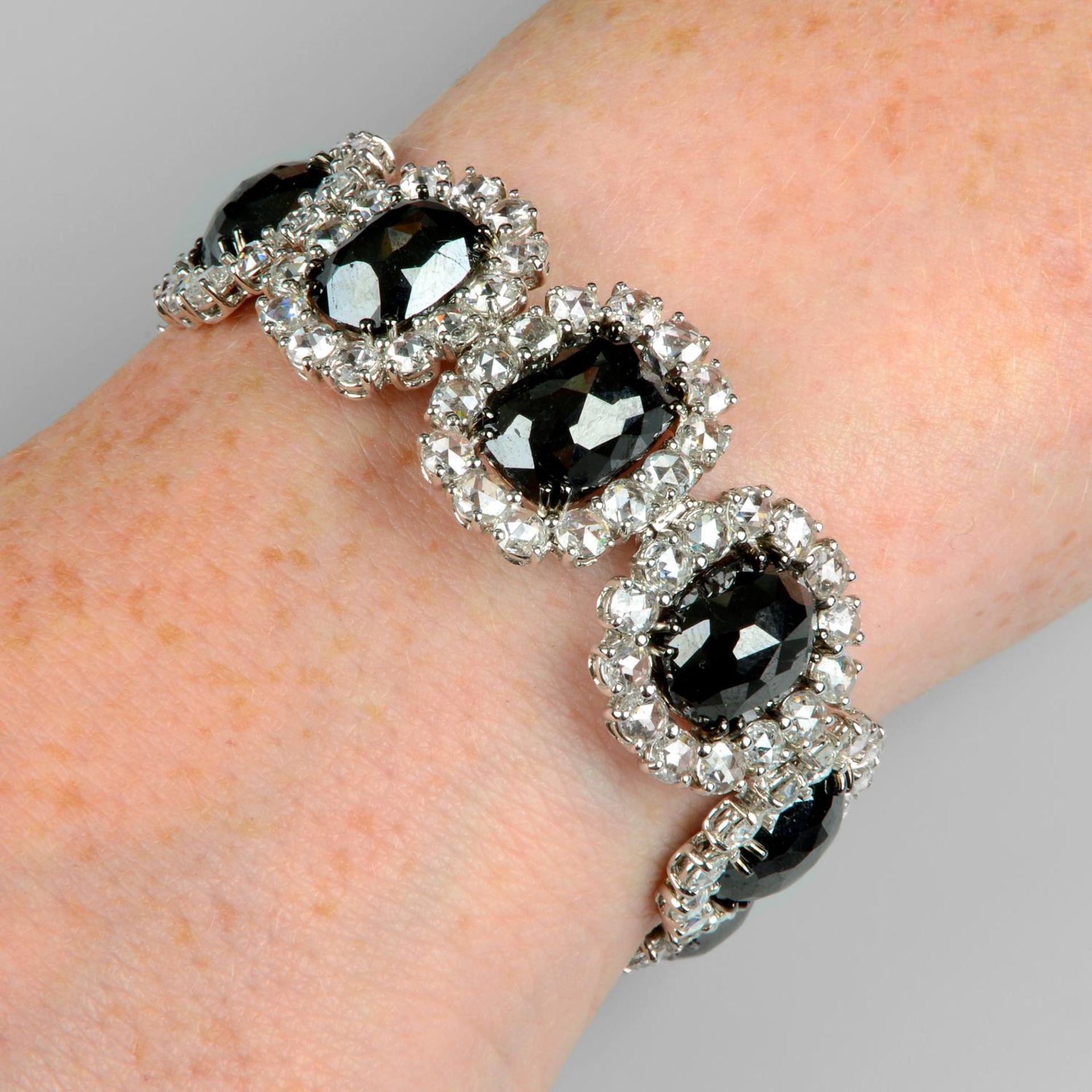 A slightly graduated 'black' diamond and rose-cut diamond cluster bracelet.Estimated dimensions of