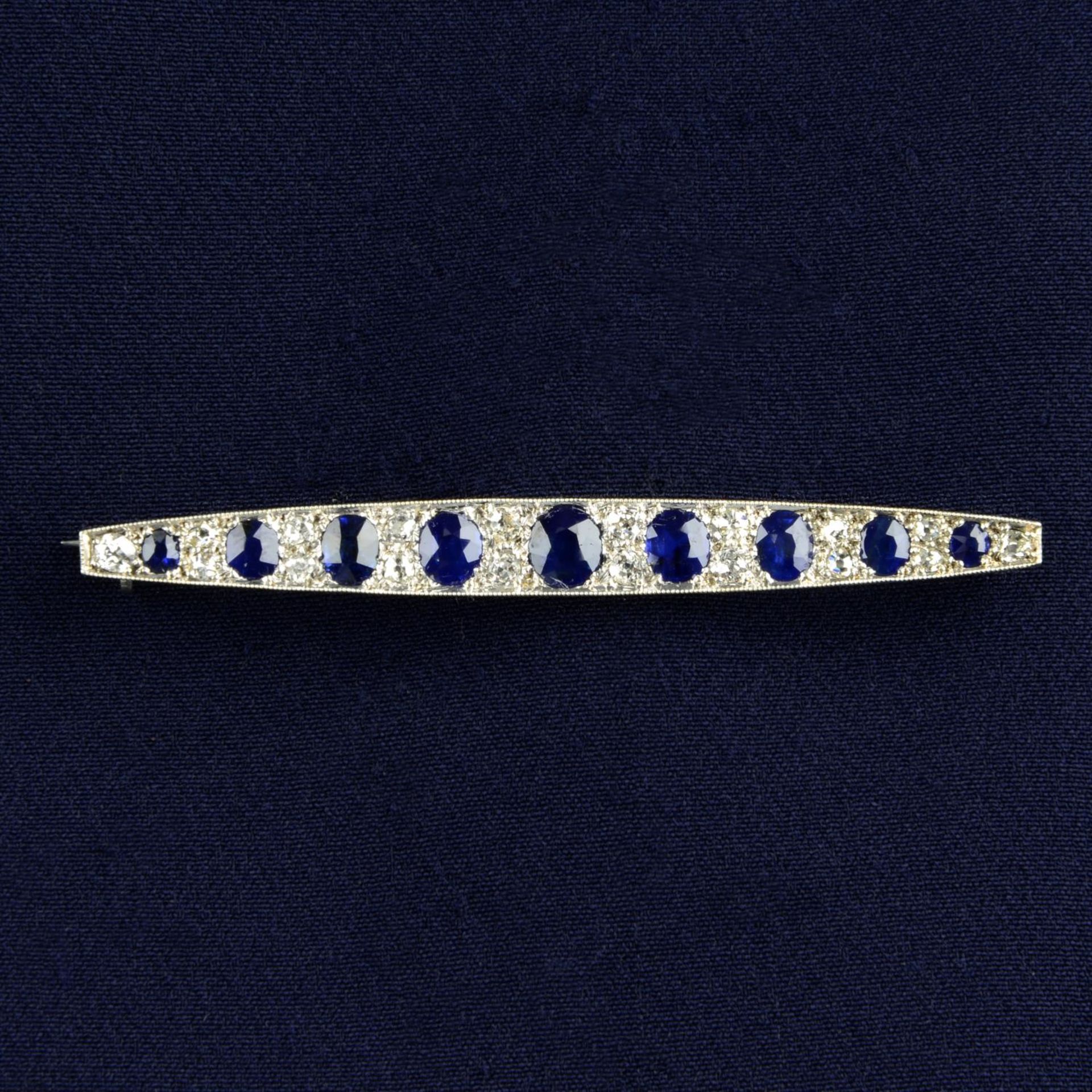 An early 20th century gold sapphire and old-cut diamond bar brooch.Central sapphire calculated