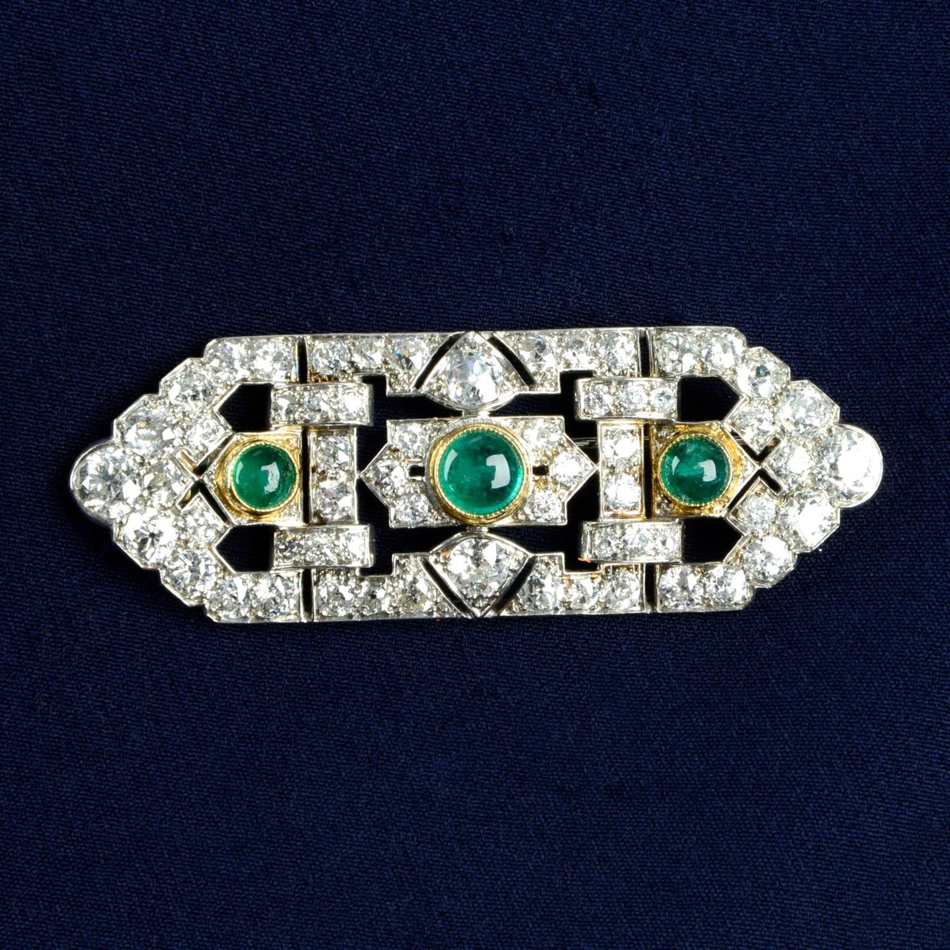 An Art Deco platinum and gold, emerald and diamond geometric brooch.