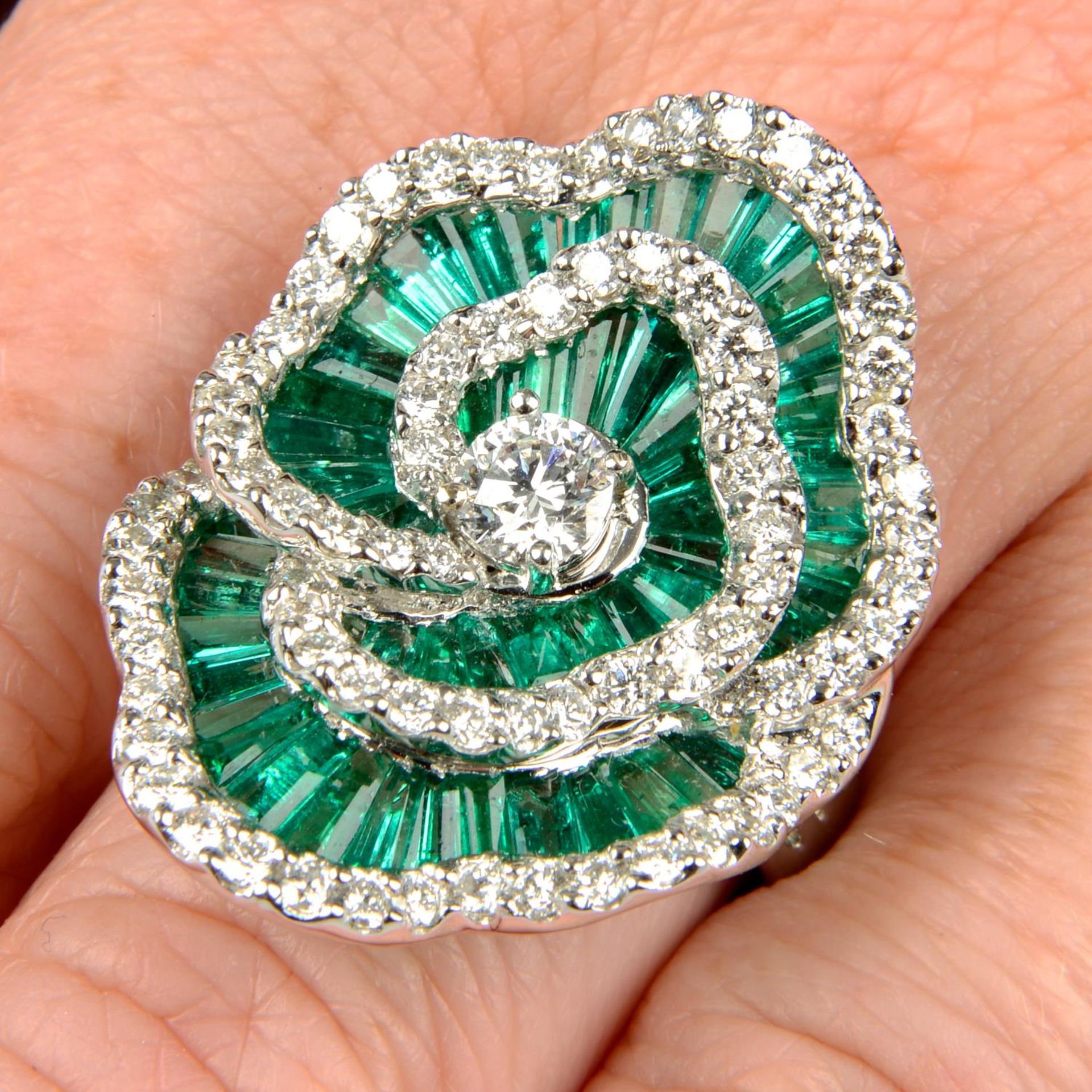 An emerald and diamond floral cocktail ring.