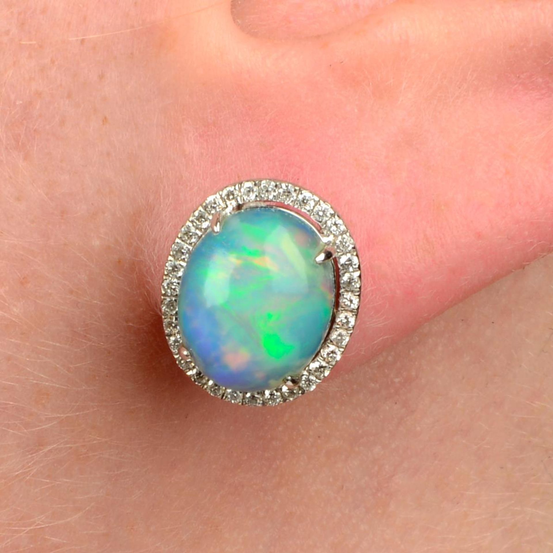 A pair of opal cabochon and brilliant-cut diamond cluster earrings.Total opal weight 3.25cts.Total