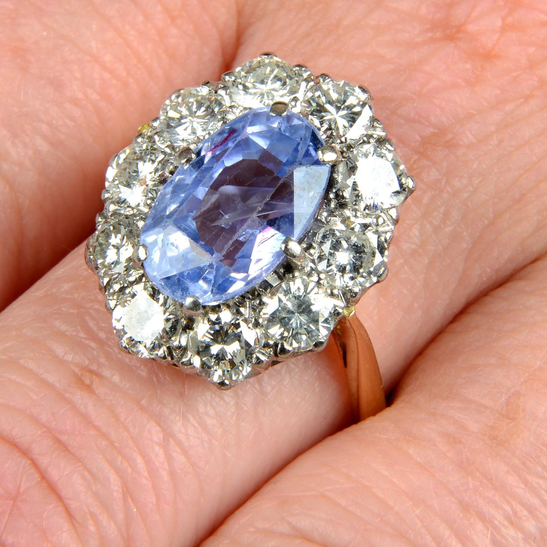 An 18ct gold Sri Lankan sapphire and brilliant-cut diamond cluster ring.With report 20012,