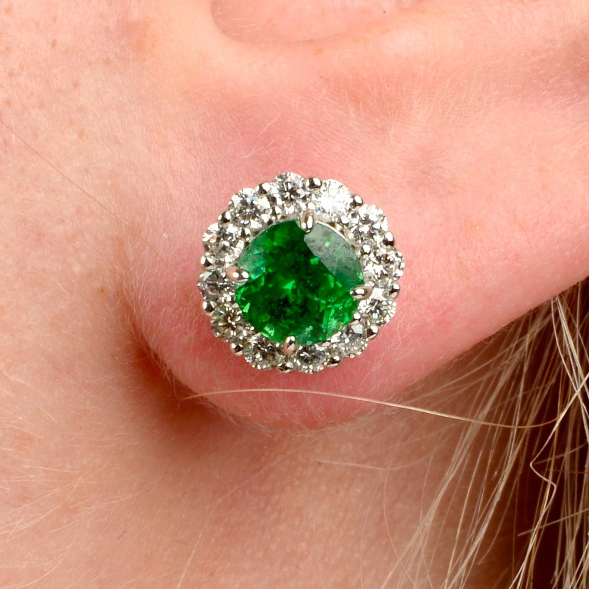 A pair of tsavorite garnet and brilliant-cut diamond cluster earrings.Estimated total diamond