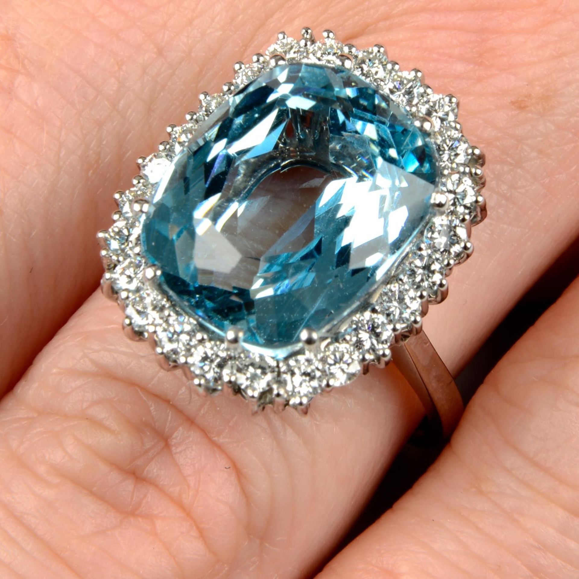 An aquamarine and diamond cluster ring.Aquamarine weight 10.94cts.Estimated total diamond weight