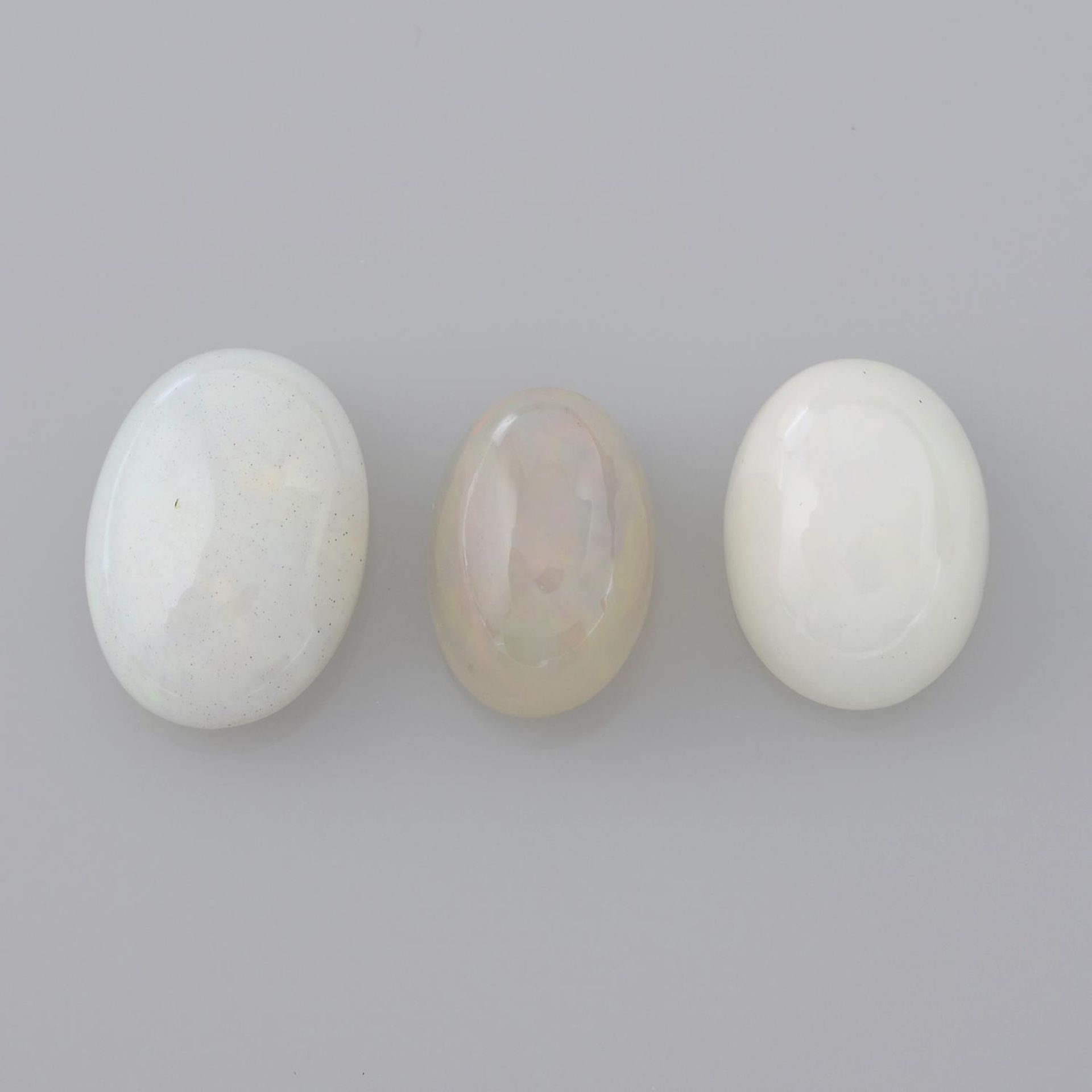 A selection of gemstones, to include six aquamarines, three peridots and three opals.