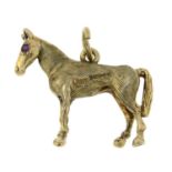 A 9ct gold horse pendant with ruby eyes.Hallmarks for London, 1965.Length 2.3cms 4.5gms.