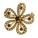 A 9ct gold seed pearl and garnet floral brooch.Hallmarks for London, 1974.Length 2.5cms.