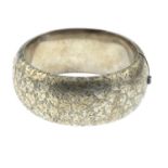An early to mid 20th century silver hinged bangle,
