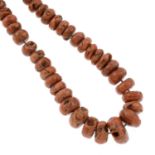 A coral necklace, along with loose coral beads.Length of necklace 244cms.