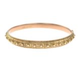An Edwardian 9ct gold cannetille hinged bangle.Hallmarks for Chester, 1905.Inner diameter 6cms.